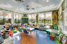 Spacious room featuring panoramic windows, custom mural artwork, recessed lighting, and a multi-toned flooring design with wood-finish and blue sectio