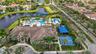 Expansive community amenities featuring multiple pools, sport courts, and a central clubhouse with a tiled roof
