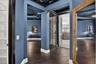 Deep blue walls with white baseboards, dark wood-finish flooring, and dark wood trim