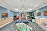 Recreation room featuring patterned carpet, light blue walls with wainscoting, recessed lighting, and crown molding