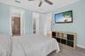 Bedroom featuring a ceiling fan, light blue wall paint, wood-finish flooring, and crown molding