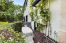 Exterior utility area featuring a standby generator, multiple electrical panels, and air conditioning units