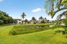 Expansive green lawn with a natural water feature