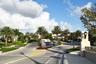 Paved entryway featuring a multi-tiered fountain and lush tropical landscaping