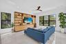 Living area featuring a full-wall built-in entertainment unit with shelving and cabinetry, large format tile flooring, and recessed lighting