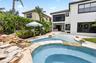Backyard oasis featuring a custom rock waterfall, integrated pool and spa, and a spacious paver patio