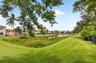 Expansive green lawn bordering a tranquil pond