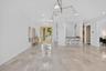Spacious entry foyer featuring large format tile flooring, a built-in wet bar with seating, recessed lighting, and a contemporary ceiling light fixtur