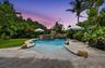 Custom-shaped swimming pool featuring a rock waterfall and integrated fountains