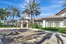 Mediterranean-style exterior featuring a prominent arched entry with sconce lighting, an octagonal tower, and a terracotta tile roof