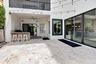 Spacious outdoor patio featuring natural stone flooring, an integrated outdoor bar with a stone countertop, a ceiling fan, and large sliding glass doo