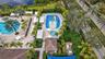Resort-style pool area featuring a large swimming pool, separate splash pad, spa, and ample lounge seating with cabanas