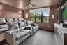 Dedicated media room featuring wood-finish flooring, a contemporary ceiling fan, and a built-in media console with a light-toned countertop