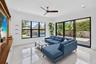 Spacious living area featuring polished tile flooring, a dark wood-finish ceiling fan, and recessed lighting