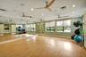 Spacious room featuring wood-finish flooring, full-wall mirrors, and multiple windows with roller shades