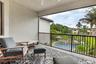 Covered outdoor balcony featuring textured stucco walls and a ceiling fan