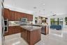 Gourmet kitchen featuring wood cabinetry, light-toned countertops, and stainless steel appliances, including double wall ovens