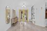 Spacious entryway featuring light-toned large format tile flooring, crown molding, and a contemporary spherical chandelier