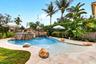 Freeform swimming pool featuring a rock waterfall, integrated spa, and an expansive sun shelf