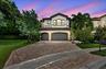 Two-story residence featuring a tile roof, arched entryway, and a two-car garage