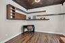 Room featuring wood-finish flooring, a decorative patterned ceiling, and a ceiling fan