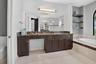 Dual vanity with an expansive countertop, integrated undermount sinks, and dark wood cabinetry