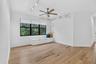 Spacious room featuring wood-finish flooring, a ceiling fan, and track lighting