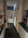 Hallway Pantry with half bath on the right, laundry room beyond and garage door at the end.
