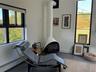 Sitting room with a wood stove, a baseboard heating unit, and tile patterned floors