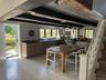 Dining room featuring stairway, beam ceiling, finished concrete flooring, and wooden walls