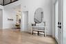 Entry hallway with console table, mirror, and staircase in background