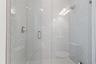 Glass-enclosed shower with tile surround