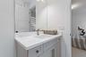 Bathroom with gray vanity, marble countertop, and mirror