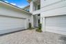 Side exterior view with two-car garage and paver driveway