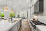 Kitchen with large island, professional range with hood, and view to outdoors