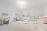 Bedroom with white furniture, floral bedding, and desk area