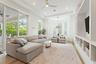 Living room with sectional sofa, mounted TV, built-in shelving, and French doors to outside