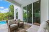 Outdoor sitting nook with wicker furniture and pool view