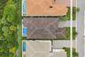 Overhead aerial view of the property showing roof layout, pool, and driveway