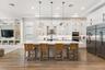 Kitchen with wood dining table, mounted TV, and dark cabinetry