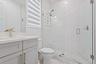 Bathroom with subway tile shower and gray vanity