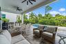 Covered patio with dining and lounge seating overlooking the pool
