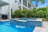 Backyard pool and spa with tiled accents and outdoor kitchen
