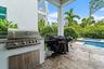 Outdoor kitchen with built-in grill and pool view