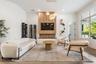 Living room with wood accent wall, wine storage shelving, mounted TV, and round coffee table