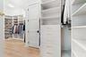 Walk-in closet with white built-in shelving and drawers