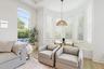 Sitting nook with bay window, armchairs, plantation shutters, and pool view