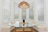 Breakfast nook with round glass table, built-in bench seating, and bay window