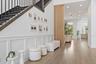 Hallway with staircase, gallery wall, and decorative garden stools