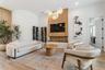 Living room with white sofa, wood accent wall, built-in wine display, and mounted TV